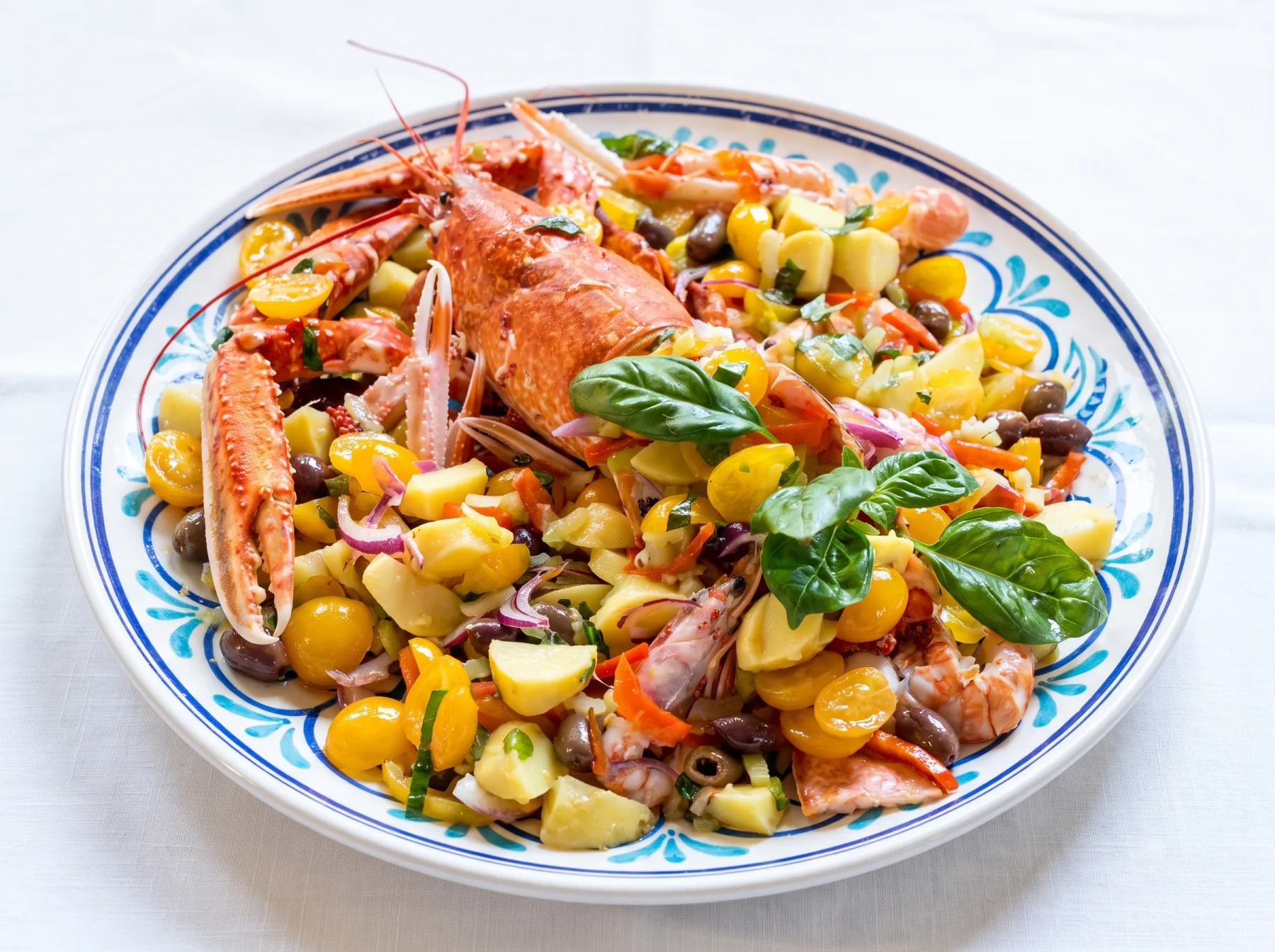 Catalana di astice con patate, pomodorini, cipolla di Tropea e olive